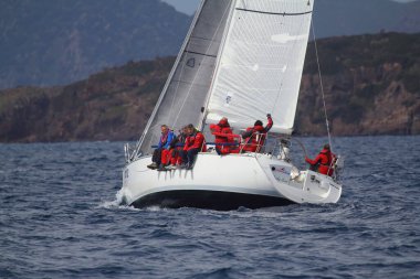 Bodrum, Hindi. 25 Mart 2018: Yelkenliler Ege Denizi 'nin mavi sularında, ünlü tatil beldesi Bodrum' un kıyılarında rüzgarlı havada yelken açıyor..