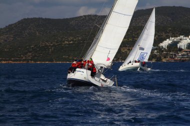 Bodrum, Hindi. 24 Mart 2018: Ege Denizi 'nin mavi sularında, ünlü tatil beldesi Bodrum' un kıyılarında yelkenliler rüzgarlı havada yelken açıyor.