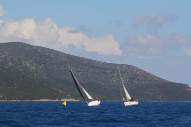 Bodrum, Hindi. 24 Mart 2018: Ege Denizi 'nin mavi sularında, ünlü tatil beldesi Bodrum' un kıyılarında yelkenliler rüzgarlı havada yelken açıyor.