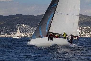Bodrum, Hindi. 24 Mart 2018: Ege Denizi 'nin mavi sularında, ünlü tatil beldesi Bodrum' un kıyılarında yelkenliler rüzgarlı havada yelken açıyor.