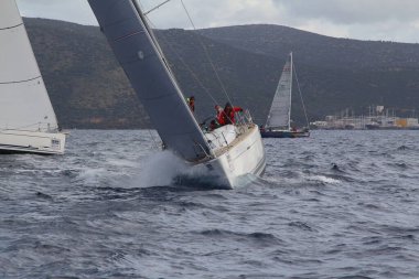 Bodrum, Hindi. 25 Mart 2018: Yelkenliler Ege Denizi 'nin mavi sularında, ünlü tatil beldesi Bodrum' un kıyılarında rüzgarlı havada yelken açıyor..