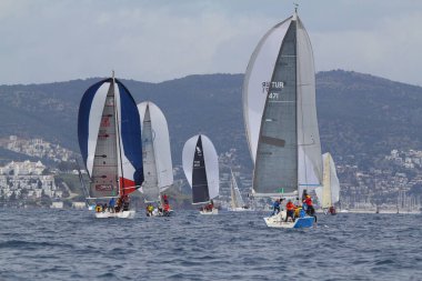 Bodrum, Hindi. 25 Mart 2018: Yelkenliler Ege Denizi 'nin mavi sularında, ünlü tatil beldesi Bodrum' un kıyılarında rüzgarlı havada yelken açıyor..