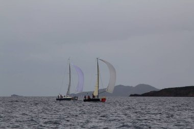 Bodrum, Hindi. 25 Mart 2018: Yelkenliler Ege Denizi 'nin mavi sularında, ünlü tatil beldesi Bodrum' un kıyılarında rüzgarlı havada yelken açıyor..