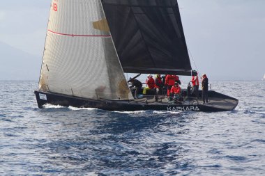 Bodrum, Hindi. 02 Mart 2019: Yelkenliler Ege Denizi 'nin mavi sularında, ünlü tatil beldesi Bodrum' un kıyılarında rüzgarlı havada yelken açıyor.