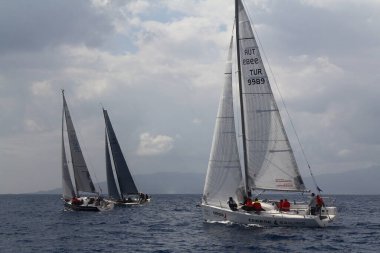 Bodrum, Hindi. 02 Mart 2019: Yelkenliler Ege Denizi 'nin mavi sularında, ünlü tatil beldesi Bodrum' un kıyılarında rüzgarlı havada yelken açıyor.