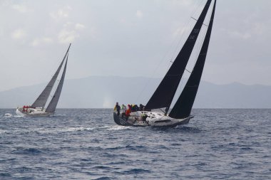 Bodrum, Hindi. 02 Mart 2019: Yelkenliler Ege Denizi 'nin mavi sularında, ünlü tatil beldesi Bodrum' un kıyılarında rüzgarlı havada yelken açıyor.