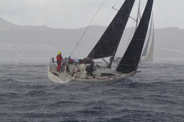 Bodrum, Hindi. 02 Mart 2019: Şiddetli yağmurda denizde yüzen yelkenliler. Yelkenliler Ege Denizi 'nin mavi sularında rüzgarlı havada yelken açarlar..  