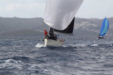 Bodrum, Hindi. 02 Mart 2019: Yelkenliler Ege Denizi 'nin mavi sularında, ünlü tatil beldesi Bodrum' un kıyılarında rüzgarlı havada yelken açıyor..