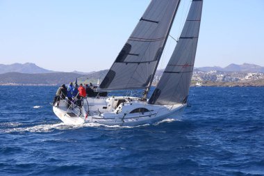 Bodrum, Hindi. 05 Şubat 2022: Yelkenliler Ege Denizi 'nin mavi sularında, ünlü tatil beldesi Bodrum' un kıyılarında rüzgarlı havada yelken açıyorlar..