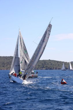 Bodrum, Hindi. 06 Şubat 2022: Yelkenliler Ege Denizi 'nin mavi sularında, ünlü tatil beldesi Bodrum' un kıyılarında rüzgarlı havada yelken açıyorlar..