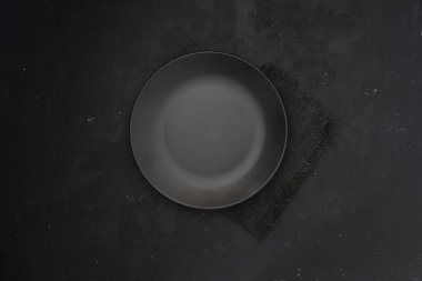 Karanlık taş masada boş siyah levha. Menü için yemek geçmişi, tarif. Masa ayarı. Flatlay, üst manzara. Restoran yemeği için maket.