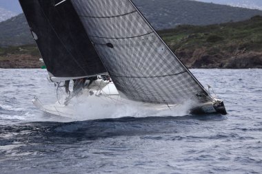 Bodrum, Hindi. 27 Şubat 2022: Yelkenliler Ege Denizi 'nin mavi sularında, ünlü tatil beldesi Bodrum' un kıyılarında rüzgarlı havada yelken açıyorlar..