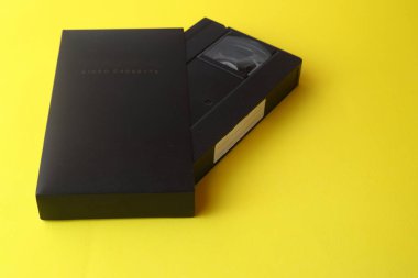 Sarı arkaplanda boş etiketli siyah VHS video kaseti