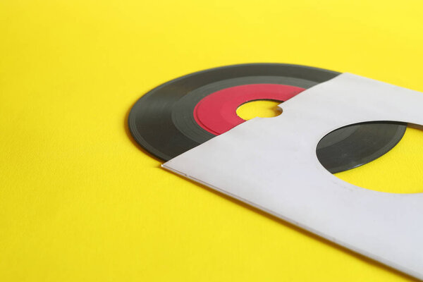 45rpm Vinyl Record with Sleeve. close up vinyl on yellow background. 