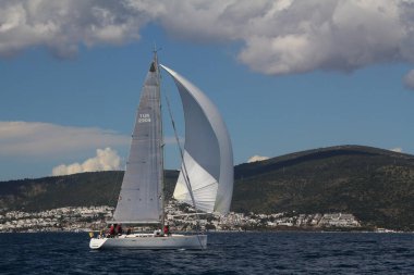 Bodrum, Hindi. 14 Nisan 2019: Yelkenliler Ege Denizi 'nin mavi sularında, ünlü tatil beldesi Bodrum' un kıyılarında rüzgarlı havada yelken açıyor..