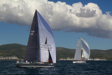 Bodrum, Hindi. 14 Nisan 2019: Yelkenliler Ege Denizi 'nin mavi sularında, ünlü tatil beldesi Bodrum' un kıyılarında rüzgarlı havada yelken açıyor..
