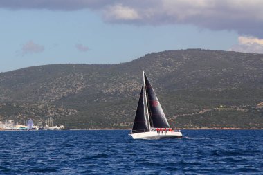 Bodrum, Hindi. 14 Nisan 2019: Yelkenliler Ege Denizi 'nin mavi sularında, ünlü tatil beldesi Bodrum' un kıyılarında rüzgarlı havada yelken açıyor..