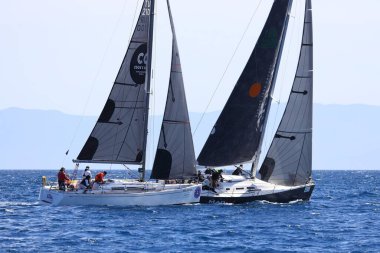 Bodrum, Hindi. 09 Nisan 2022: Yelkenliler Ege Denizi 'nin mavi sularında, ünlü tatil beldesi Bodrum' un kıyılarında rüzgarlı havada yelken açıyor.