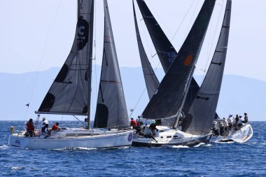 Bodrum, Hindi. 09 Nisan 2022: Yelkenliler Ege Denizi 'nin mavi sularında, ünlü tatil beldesi Bodrum' un kıyılarında rüzgarlı havada yelken açıyor.