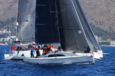 Bodrum, Hindi. 09 Nisan 2022: Yelkenliler Ege Denizi 'nin mavi sularında, ünlü tatil beldesi Bodrum' un kıyılarında rüzgarlı havada yelken açıyor.