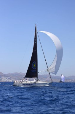 Bodrum, Hindi. 07 Mayıs 2022: Ege Denizi 'nin mavi sularında, ünlü tatil beldesi Bodrum' un kıyılarında yelkenliler rüzgarlı havada yelken açıyor.