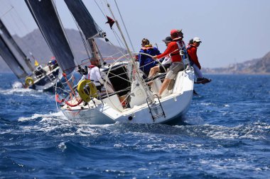 Bodrum, Hindi. 07 Mayıs 2022: Ege Denizi 'nin mavi sularında, ünlü tatil beldesi Bodrum' un kıyılarında yelkenliler rüzgarlı havada yelken açıyor.