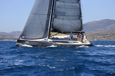 Bodrum, Hindi. 07 Mayıs 2022: Ege Denizi 'nin mavi sularında, ünlü tatil beldesi Bodrum' un kıyılarında yelkenliler rüzgarlı havada yelken açıyor.