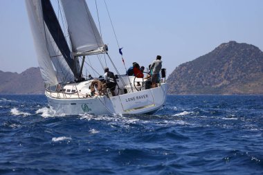 Bodrum, Hindi. 07 Mayıs 2022: Ege Denizi 'nin mavi sularında, ünlü tatil beldesi Bodrum' un kıyılarında yelkenliler rüzgarlı havada yelken açıyor.