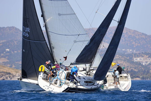 Бодрум, Турция. 07 мая 2022: Парусники плывут в ветреную погоду в голубых водах Эгейского моря, на берегу знаменитого курорта Бодрум.