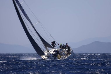 Bodrum, Hindi. 07 Mayıs 2022: Ege Denizi 'nin mavi sularında, ünlü tatil beldesi Bodrum' un kıyılarında yelkenliler rüzgarlı havada yelken açıyor.