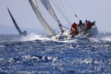 Bodrum, Hindi. 07 Mayıs 2022: Ege Denizi 'nin mavi sularında, ünlü tatil beldesi Bodrum' un kıyılarında yelkenliler rüzgarlı havada yelken açıyor.