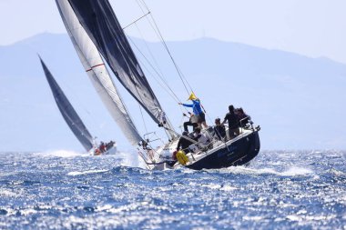 Bodrum, Hindi. 07 Mayıs 2022: Ege Denizi 'nin mavi sularında, ünlü tatil beldesi Bodrum' un kıyılarında yelkenliler rüzgarlı havada yelken açıyor.