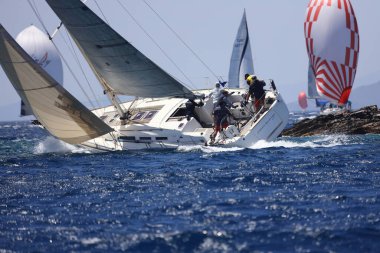 Bodrum, Hindi. 07 Mayıs 2022: Ege Denizi 'nin mavi sularında, ünlü tatil beldesi Bodrum' un kıyılarında yelkenliler rüzgarlı havada yelken açıyor.