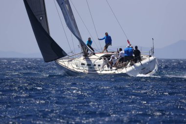 Bodrum, Hindi. 07 Mayıs 2022: Ege Denizi 'nin mavi sularında, ünlü tatil beldesi Bodrum' un kıyılarında yelkenliler rüzgarlı havada yelken açıyor.