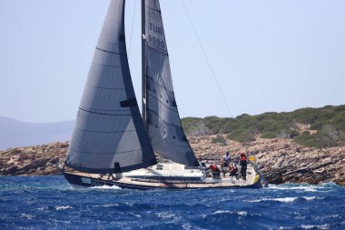 Bodrum, Hindi. 07 Mayıs 2022: Ege Denizi 'nin mavi sularında, ünlü tatil beldesi Bodrum' un kıyılarında yelkenliler rüzgarlı havada yelken açıyor.