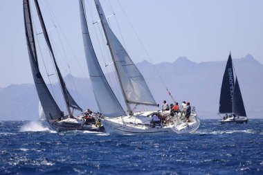 Bodrum, Hindi. 07 Mayıs 2022: Ege Denizi 'nin mavi sularında, ünlü tatil beldesi Bodrum' un kıyılarında yelkenliler rüzgarlı havada yelken açıyor.