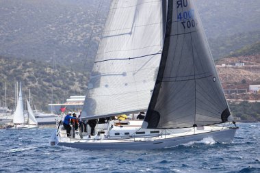 Bodrum, Hindi. 10 Nisan 2022: Yelkenliler Ege Denizi 'nin mavi sularında, ünlü tatil beldesi Bodrum' un kıyılarında rüzgarlı havada yelken açıyorlar..