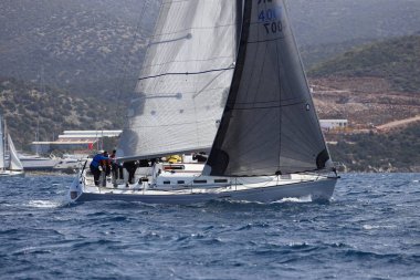 Bodrum, Hindi. 10 Nisan 2022: Yelkenliler Ege Denizi 'nin mavi sularında, ünlü tatil beldesi Bodrum' un kıyılarında rüzgarlı havada yelken açıyorlar..