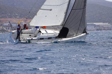 Bodrum, Hindi. 10 Nisan 2022: Yelkenliler Ege Denizi 'nin mavi sularında, ünlü tatil beldesi Bodrum' un kıyılarında rüzgarlı havada yelken açıyorlar..