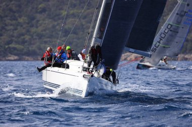 Bodrum, Hindi. 10 Nisan 2022: Yelkenliler Ege Denizi 'nin mavi sularında, ünlü tatil beldesi Bodrum' un kıyılarında rüzgarlı havada yelken açıyorlar..