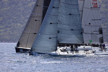 Bodrum, Hindi. 10 Nisan 2022: Yelkenliler Ege Denizi 'nin mavi sularında, ünlü tatil beldesi Bodrum' un kıyılarında rüzgarlı havada yelken açıyorlar..