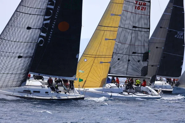 Bodrum, Hindi. 10 Nisan 2022: Yelkenliler Ege Denizi 'nin mavi sularında, ünlü tatil beldesi Bodrum' un kıyılarında rüzgarlı havada yelken açıyorlar..