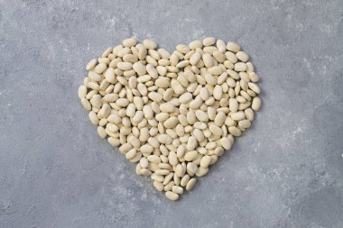 white kidney beans in a heart shaped a on white background.Top view.