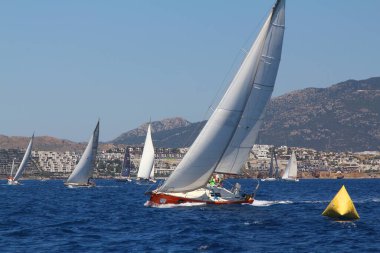 Bodrum, Hindi. 25 Mayıs 2019: Yelkenliler Ege Denizi 'nin mavi sularında, ünlü tatil beldesi Bodrum' un kıyılarında rüzgarlı havada yelken açıyorlar..