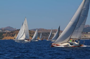 Bodrum, Hindi. 25 Mayıs 2019: Yelkenliler Ege Denizi 'nin mavi sularında, ünlü tatil beldesi Bodrum' un kıyılarında rüzgarlı havada yelken açıyorlar..