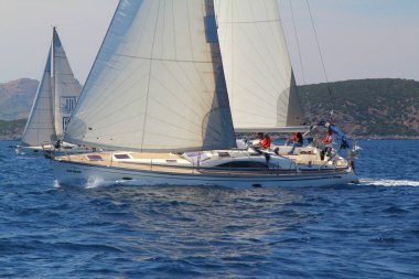 Bodrum, Hindi. 25 Mayıs 2019: Yelkenliler Ege Denizi 'nin mavi sularında, ünlü tatil beldesi Bodrum' un kıyılarında rüzgarlı havada yelken açıyorlar..