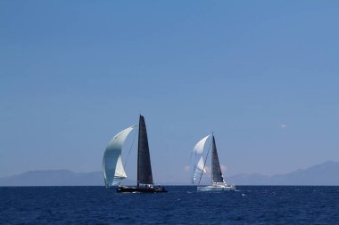 Bodrum, Hindi. 25 Mayıs 2019: Yelkenliler Ege Denizi 'nin mavi sularında, ünlü tatil beldesi Bodrum' un kıyılarında rüzgarlı havada yelken açıyorlar..