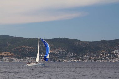 Bodrum, Hindi. 25 Mayıs 2019: Yelkenliler Ege Denizi 'nin mavi sularında, ünlü tatil beldesi Bodrum' un kıyılarında rüzgarlı havada yelken açıyorlar..