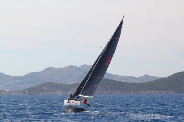 Bodrum, Hindi. 25 Mayıs 2019: Yelkenliler Ege Denizi 'nin mavi sularında, ünlü tatil beldesi Bodrum' un kıyılarında rüzgarlı havada yelken açıyorlar..