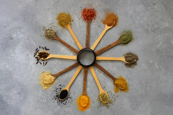 different kinds of spices in the form of a clock. Different kind of spices on a wood background. Big set of Indian spices on wooden table. Top view, Horizontal image. Flat lay.